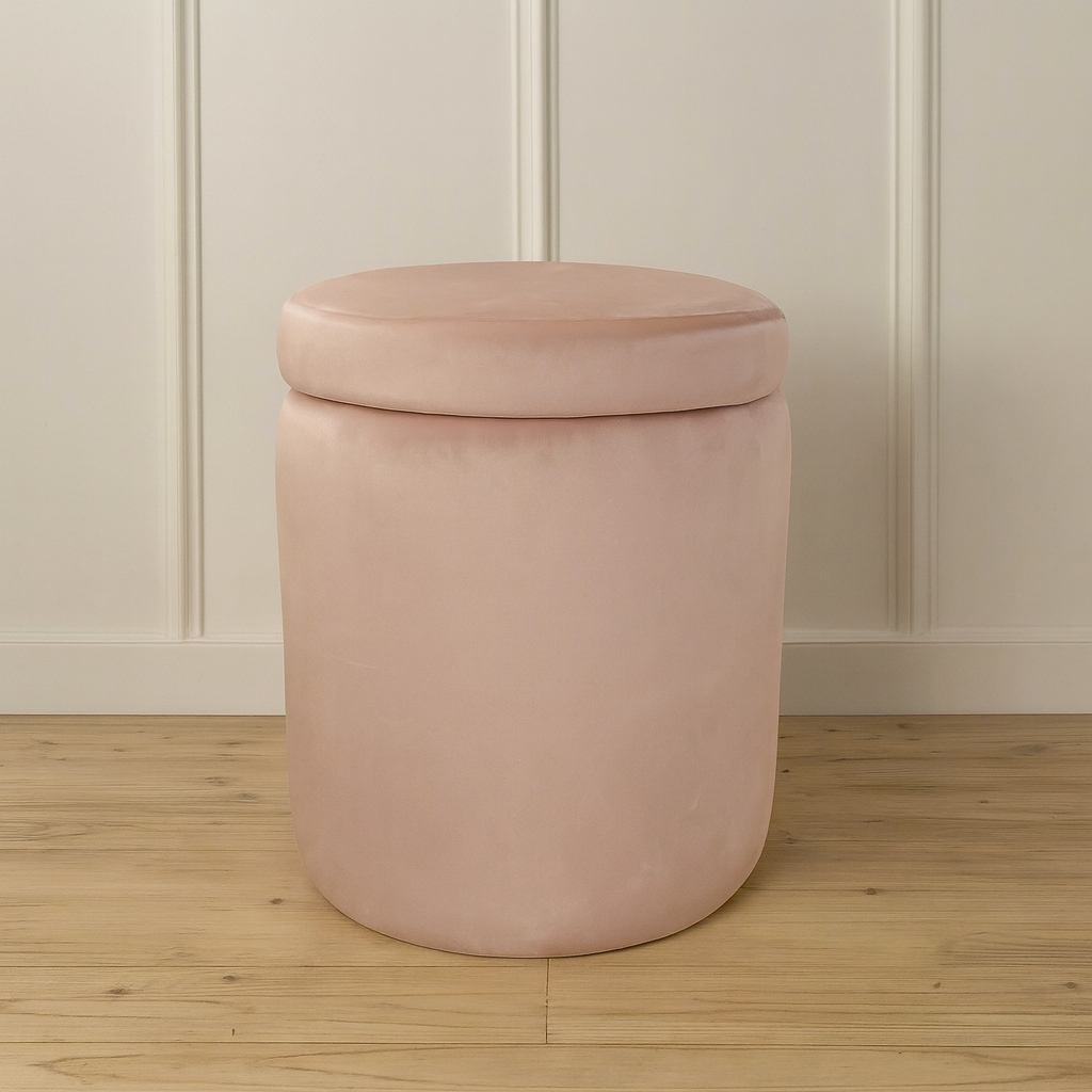 Pink cylindrical storage ottoman against a neutral wall.