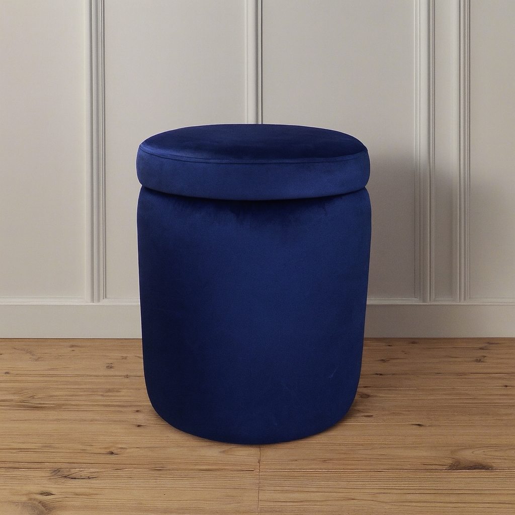 Blue cylindrical ottoman with lid on a wooden floor with a white paneled wall background