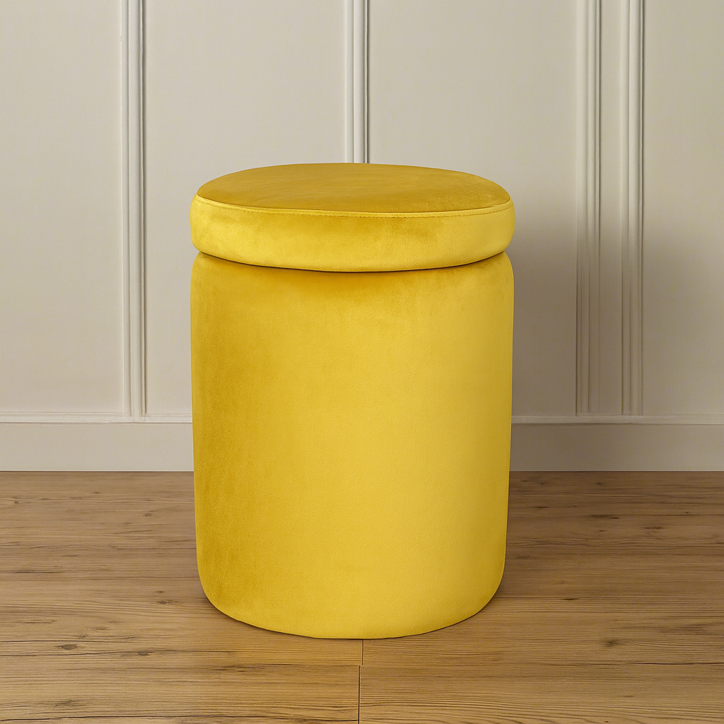 Yellow ottoman dressing stool with a cushioned lid on a wooden floor against a panelled wall.