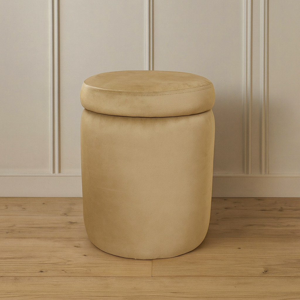 Beige cylindrical ottoman with a lid on a wooden floor against a beige paneled wall.