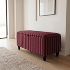 Maroon striped ottoman in Clarke & Clarke fabric in a room with light wood flooring and a window.