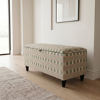 Elegant hallway with an upholstered storage bench seating in a stripe box Paxton James hare fabric and black feet. Stood on a wooden floor. 