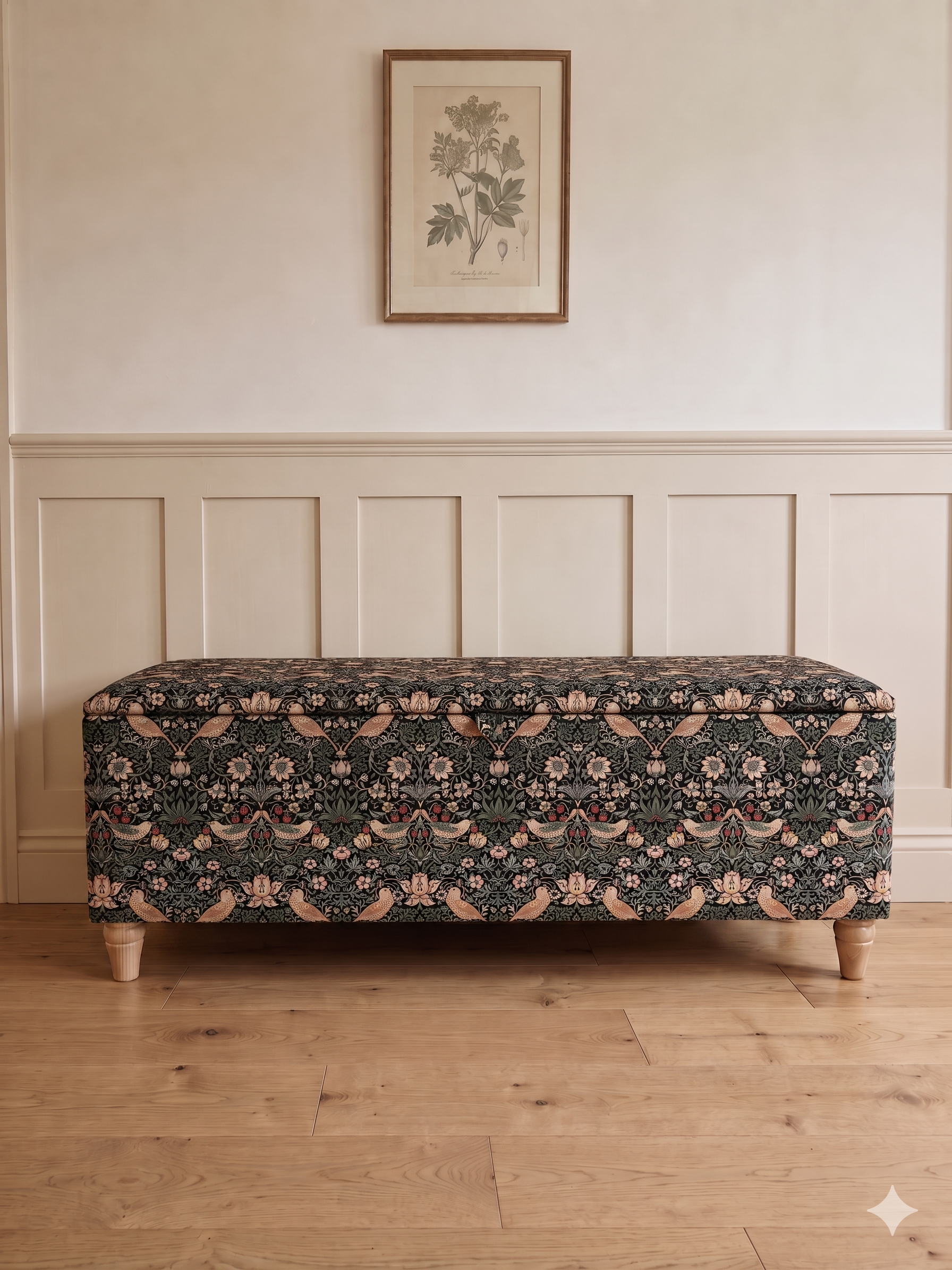 Storage bench in Black Strawberry thief William morris fabric on a light wooden floor with panelled walls behind