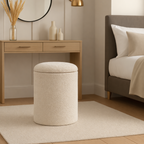 Beige ottoman in a bedroom setting with a desk and bed in the background.