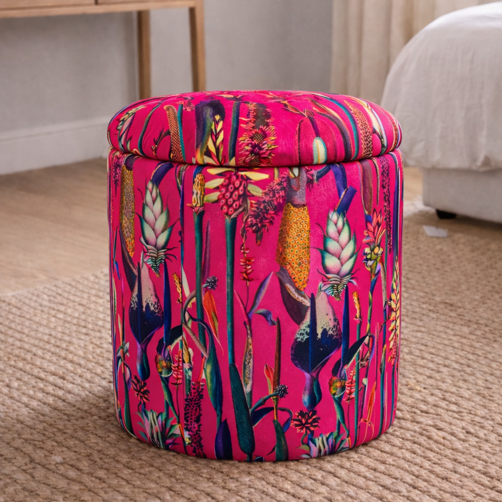 Colorful patterned ottoman in a room with a desk and window.