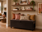 Living room with a brown storage bench with a side pet opening and decorative pillows, and shelves with decor items.