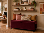 Living room with a burgundy storage bench with a side hole for a pet bed, cushions, and wall art.