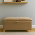 Beige ottoman in a room with a shelf displaying decor items.