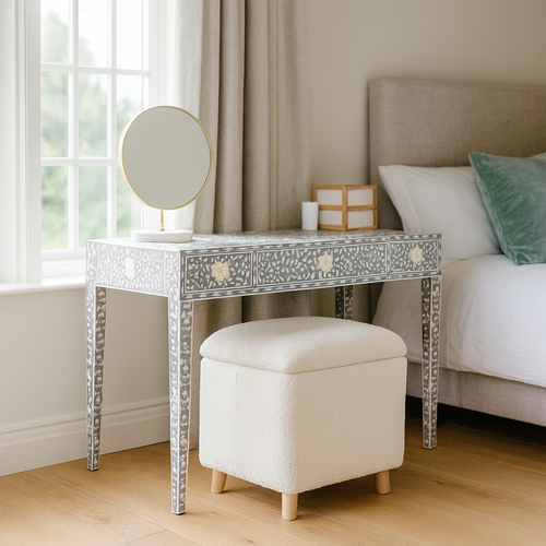 Decorative vanity table with mirror and stool in a bedroom setting