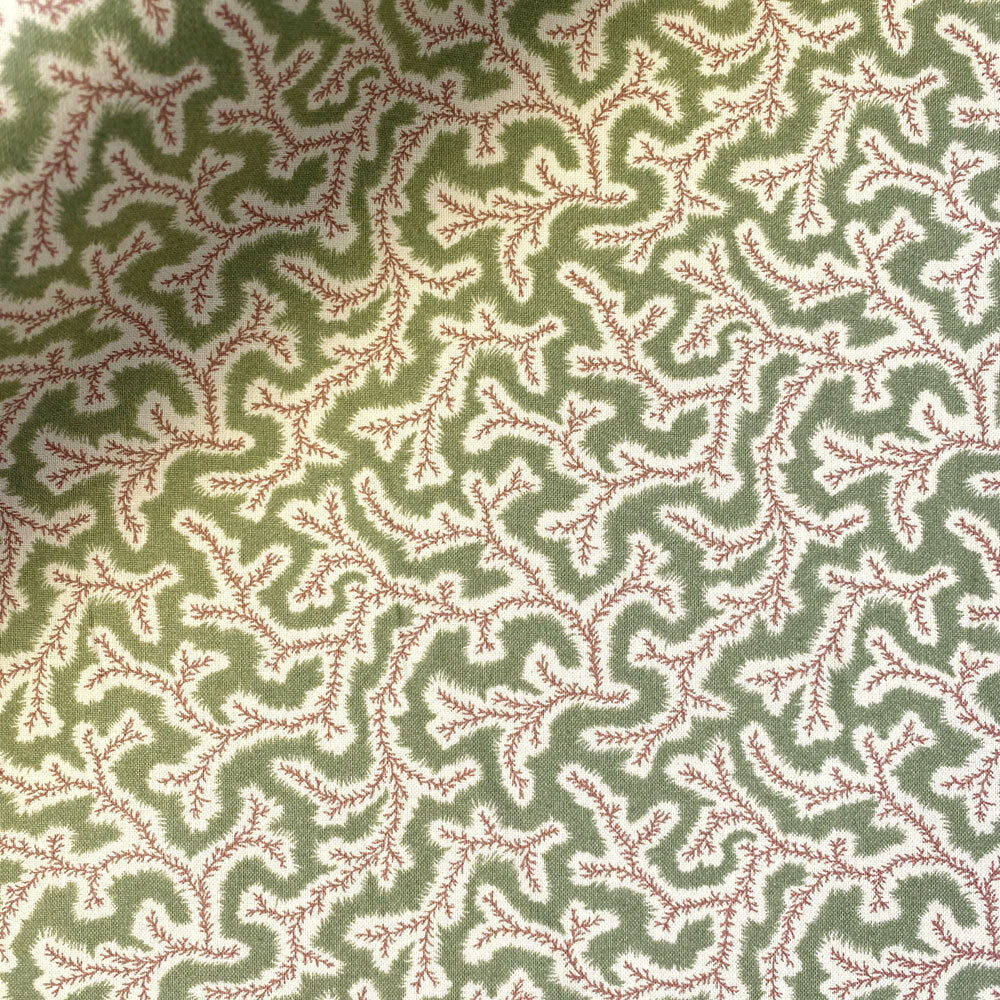 Patterned fabric with red and white design on a green background