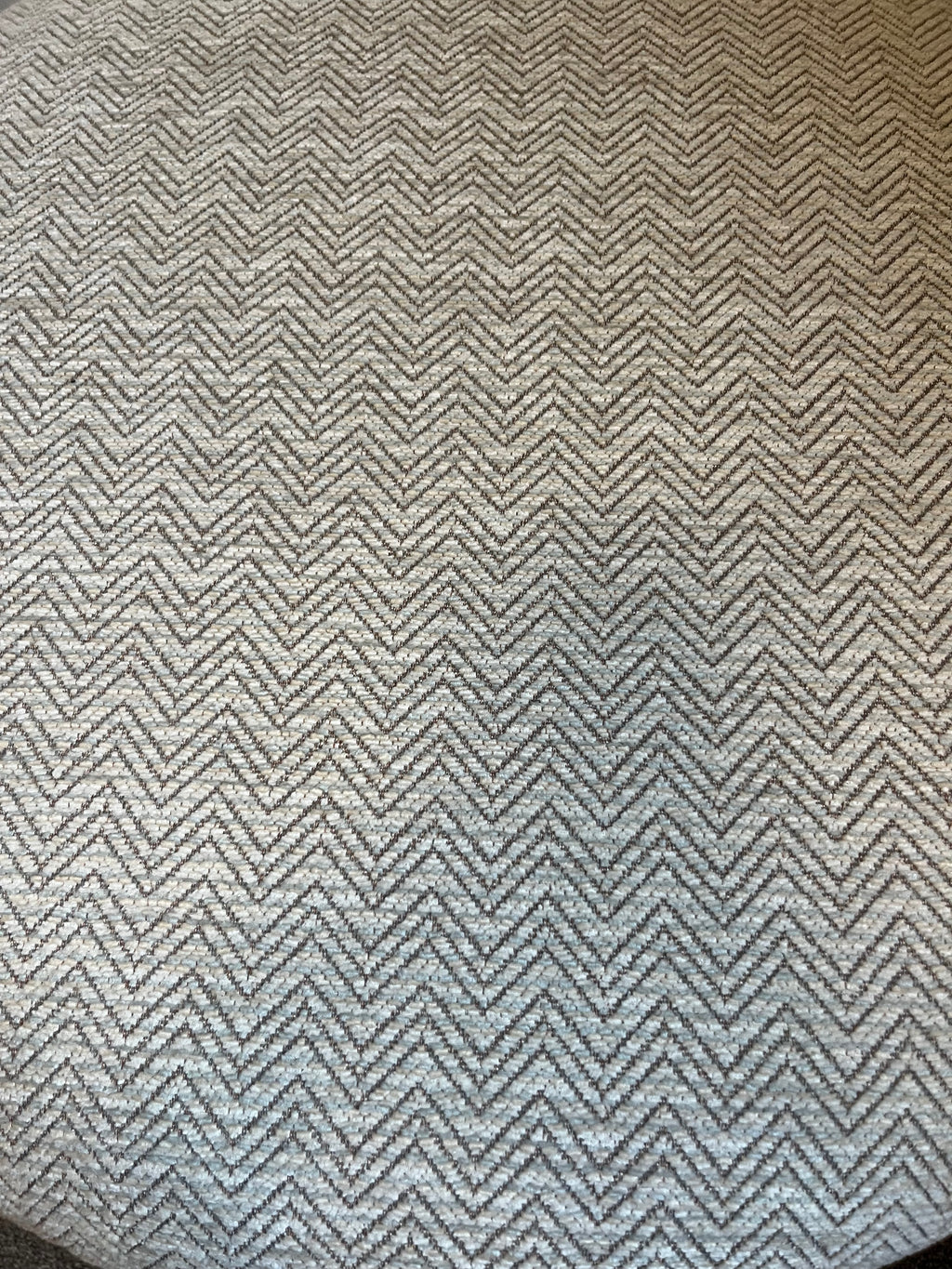 Textured fabric with a zigzag pattern in neutral beige tones with blue hints