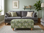 Gray velvet sofa with a floral William morris golden lily ottoman in sage, all in a modern styled living room setting