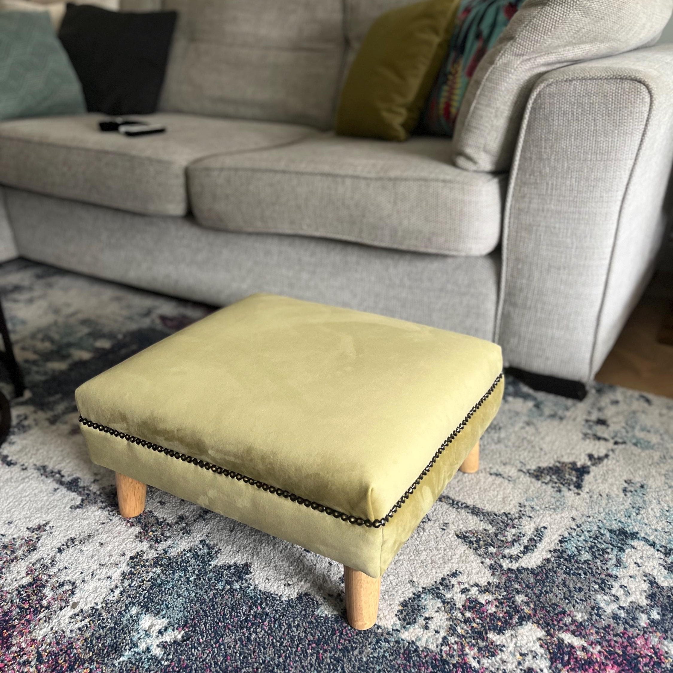 Bronze trim olive green velvet footstool wooden legs