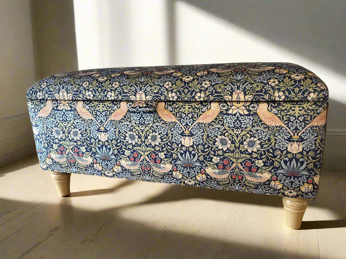 Decorative storage bench with floral pattern on a wooden floor.
