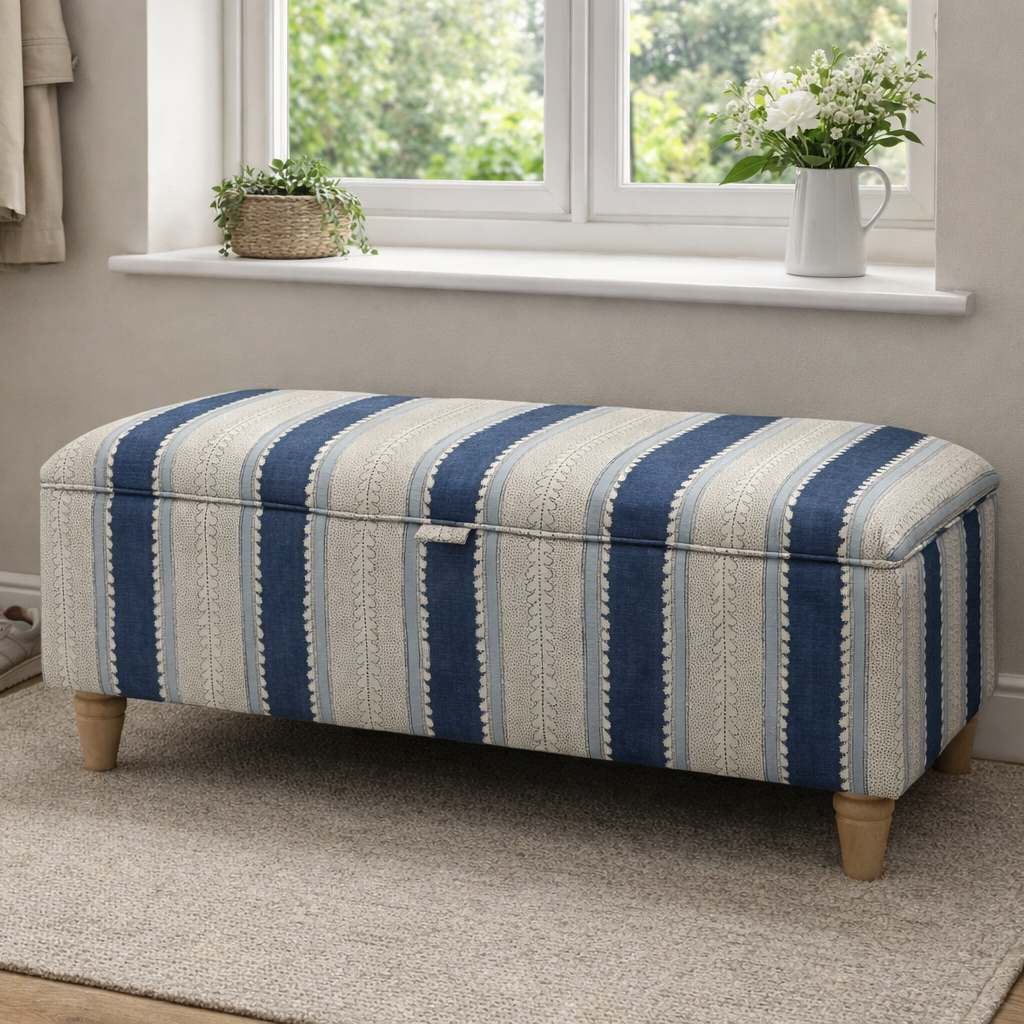 Blue Linwood Wavy Striped ottoman in a room with a window and plants
