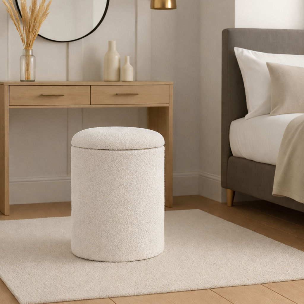 White ottoman in a bedroom setting with a desk and bed.