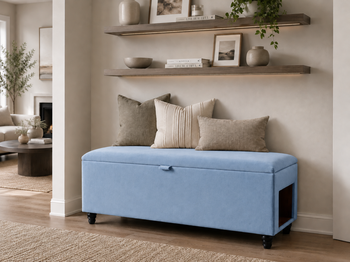 A light blue upholstered storage bench with black caster wheels, styled with four neutral-toned throw pillows in a bright, modern living room setting.