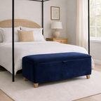 Bedroom with a four-poster bed and navy blue ottoman.