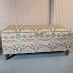Floral-patterned William Morris strawberry thief storage bench against a neutral wall.