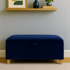 Navy blue storage ottoman in a room with a shelf featuring decor items.