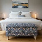 Bedroom with a bed and floral-patterned ottoman.