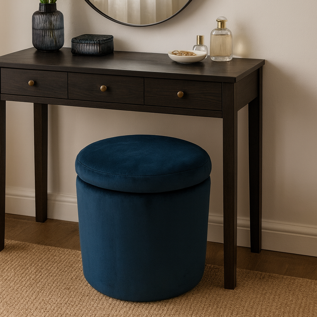 Dresser with round mirror, blue ottoman, and decorative items against a beige wall.