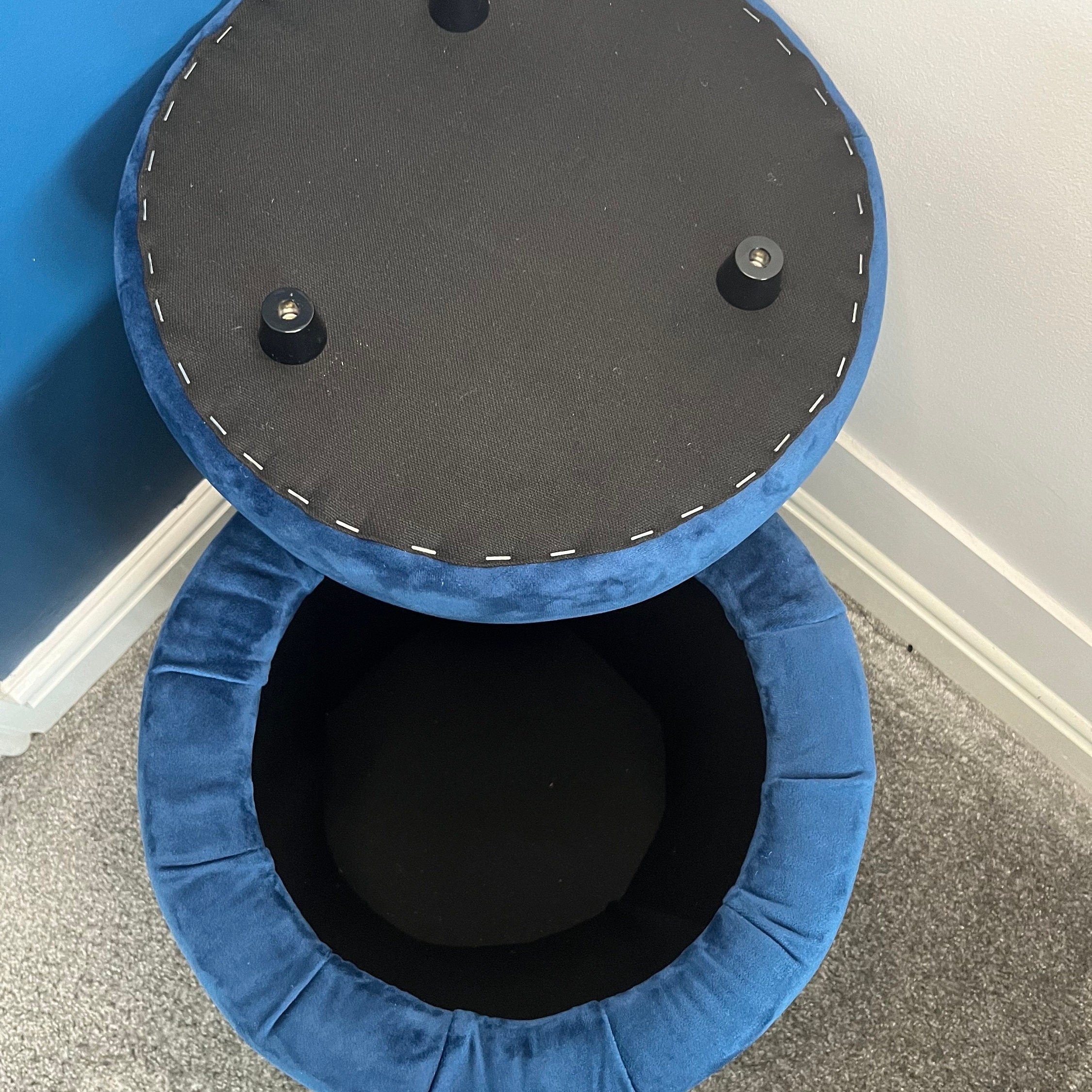 Navy blue storage stool open showing the inside and the lid with stoppers to keep it in place whilst sitting
