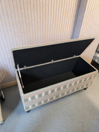 Open storage ottoman in James Hare Paxton fabric in a workshop room.