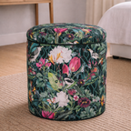 Floral-patterned ottoman in a room with a desk and bed.
