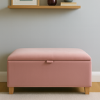 Pink storage ottoman in a room with a shelf and decor items.