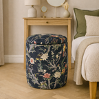 Floral-patterned ottoman in a bedroom setting with a nightstand and bed.