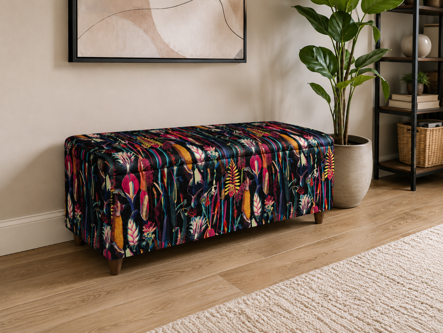 A rectangular upholstered storage bench with a colorful tropical floral pattern, styled in a modern living room setting next to a potted plant and a wooden floor.