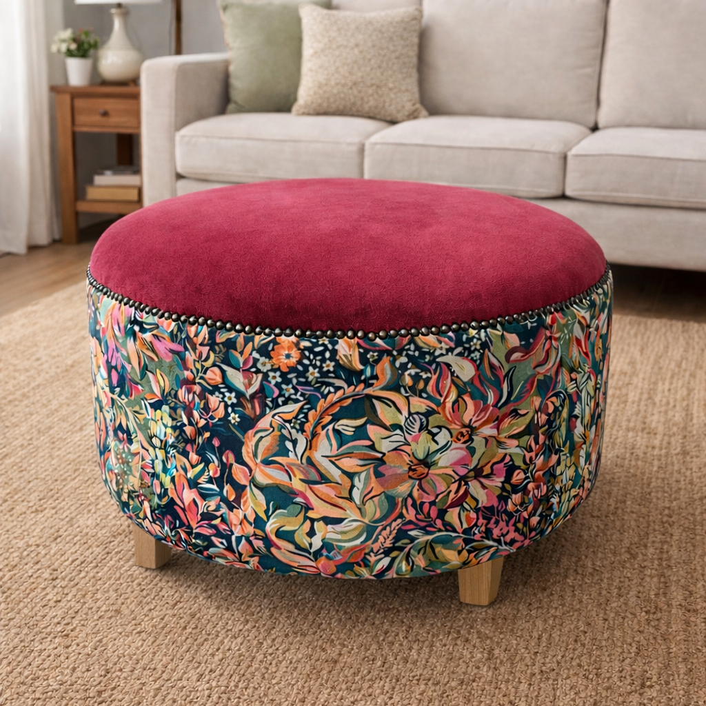 Floral-patterned ottoman with a red cushion in a living room setting.
