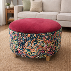 Floral-patterned ottoman with a red cushion in a living room setting.