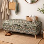 Floral-patterned vintage storage bench in a room with a coat, bag, and basket on hooks above it.