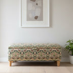 Floral-patterned cushion leaning against a wooden headboard with a textured wall in the background.