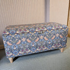Floral-patterned storage bench against a neutral wall.