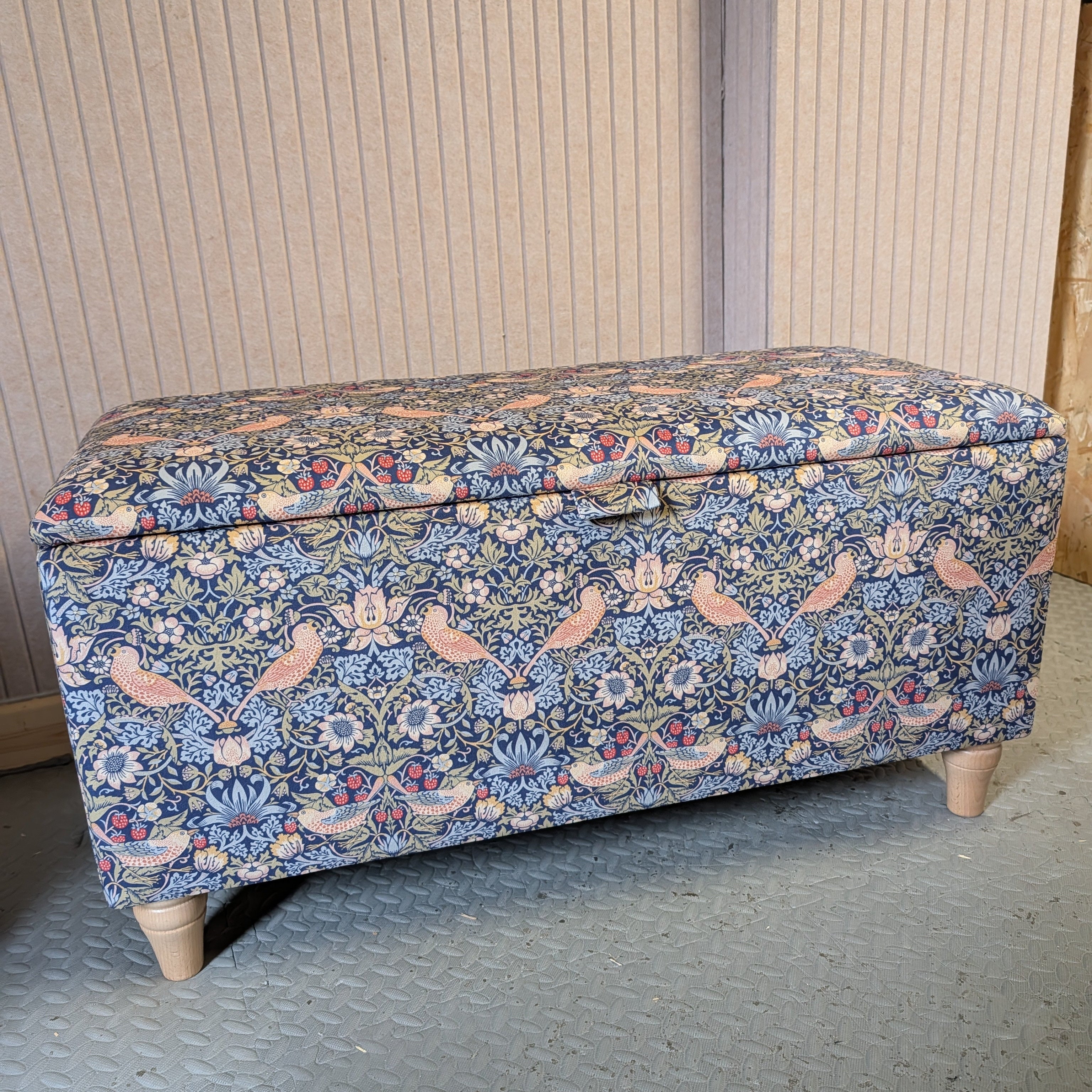 Floral-patterned storage bench against a neutral wall.