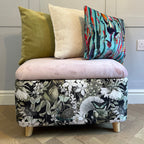 black and pink storage ottoman trunk with green and botanical cushions on top