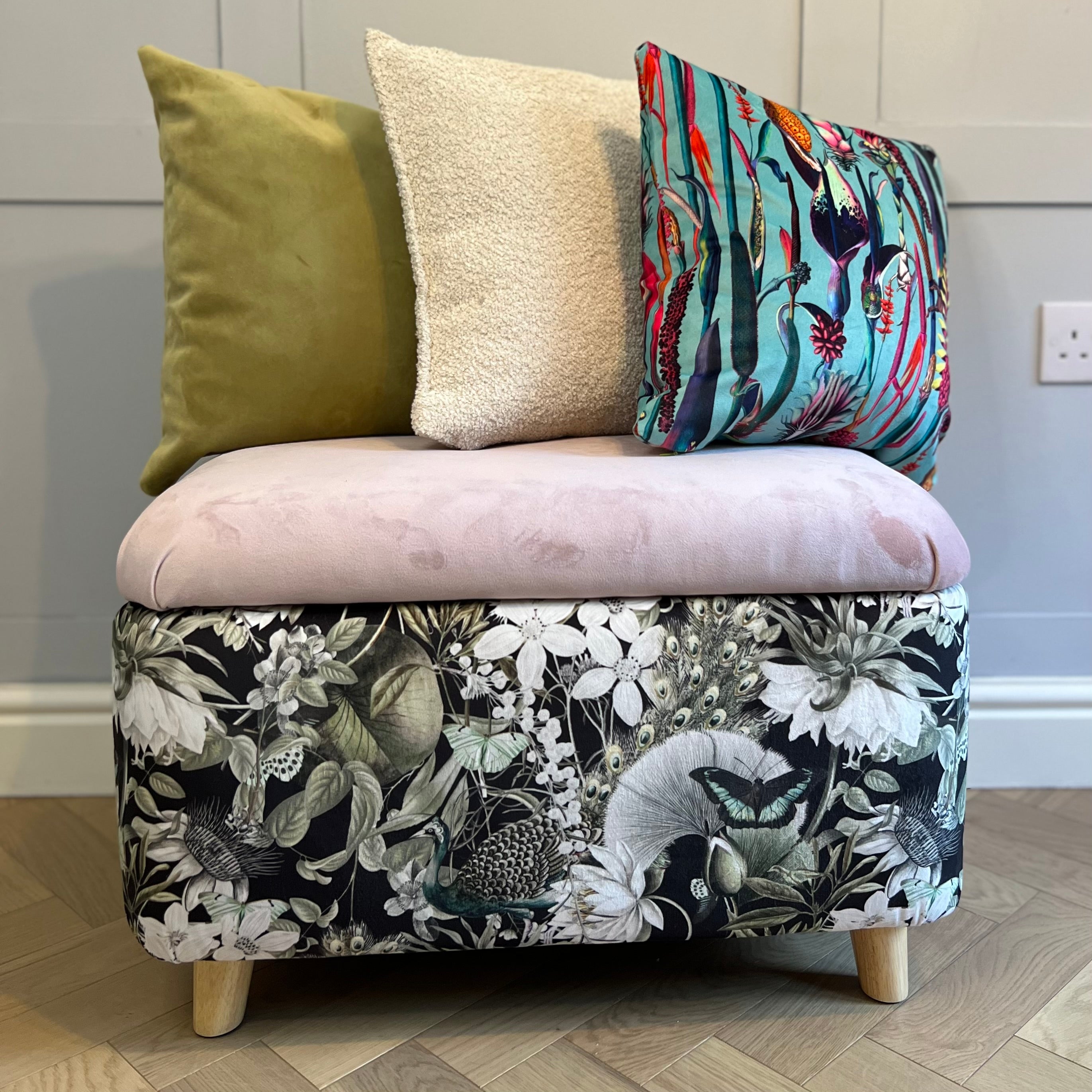 black and pink storage ottoman trunk with green and botanical cushions on top
